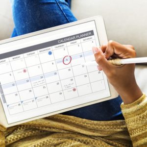Woman checking calendar on digital tablet